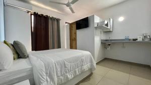 a white bedroom with a bed and a kitchen at Chill Boutique Hotel in Las Terrenas