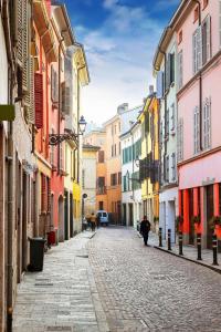 brukowana ulica w mieście z kolorowymi budynkami w obiekcie Residenza Borgo 9 w mieście Collecchio