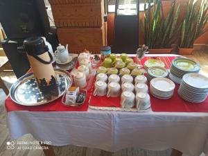 einen Tisch mit Tellern und Tassen und Essen drauf in der Unterkunft Santa Pacha in Sucre