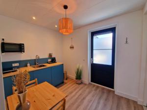 a kitchen and dining room with a table and a door at Studio Flevo Batavia in Lelystad