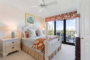 a bedroom with a bed and a balcony at Captain's Quarters Upscale 3 Bedroom Condo in Pawleys Island +20 photos