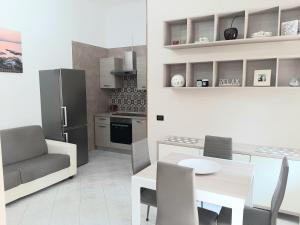 Il comprend une cuisine et une salle à manger avec une table et un réfrigérateur. dans l'établissement La casa di Nino, à Portici