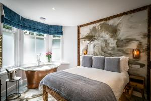 a bedroom with a bed and a bath tub and a sink at Icon - FREE off-site Health Club access with Pool, Sauna, Steam Room & Gym in Windermere