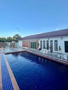 een zwembad met blauw water voor een gebouw bij HOMESTAY TERATAK AZIZAH RAHMAN Melaka in Melaka