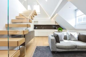 a living room with a couch and a staircase at Soho Penthouse by Concept Apartments in London