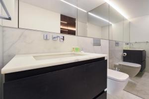 een witte badkamer met een wastafel en een toilet bij Soho Penthouse by Concept Apartments in Londen
