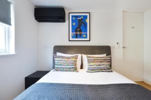 een slaapkamer met een bed en een tv aan de muur bij Soho Penthouse by Concept Apartments in Londen