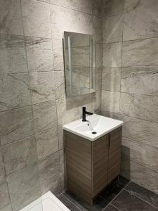 a bathroom with a sink and a mirror at Stylish Penarth Marina Apartment in Cardiff