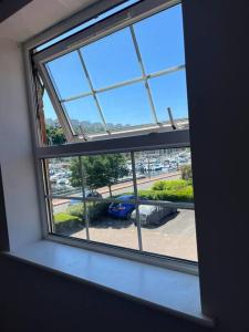 una ventana abierta con vistas a un aparcamiento en Stylish Penarth Marina Apartment, en Cardiff