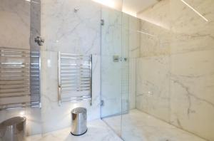 uma casa de banho com um chuveiro e uma porta de vidro em Soho Penthouse by Concept Apartments em Londres