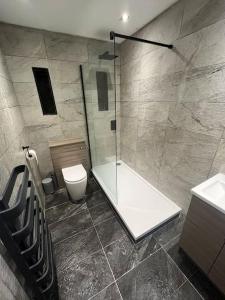 a bathroom with a shower and a toilet and a sink at Stylish Penarth Marina Apartment in Cardiff
