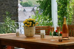 a table with a vase of flowers and a bottle of wine at Weingut & Gästehaus Stephan Kohl in Neumagen-Dhron