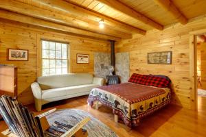 una sala de estar con una cama y un sofá en una cabaña en Stellar Wilmington House on 20 Wooded ADK Acres! en Wilmington