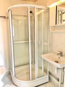 a glass shower in a bathroom with a sink at GG Village in Askim