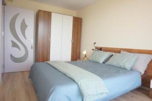 a bedroom with a blue bed with a wooden headboard at sea view hygge - Quiet residential apartment in Kavarna
