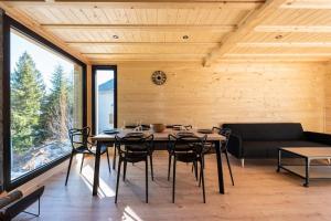 - une salle à manger avec une table, des chaises et un canapé dans l'établissement Chalet perché Chabanon - Alpes du Sud, à Selonnet