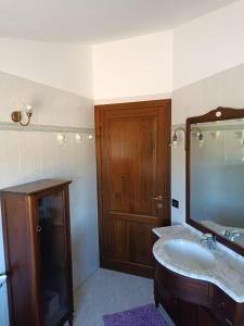 uma casa de banho com um lavatório e uma porta de madeira em A Casa di Emilie em Castelfiorentino