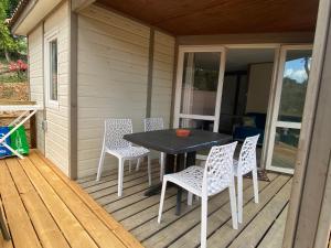 una mesa y sillas en el porche de una casa en Les chalets des Îles, en Borgo