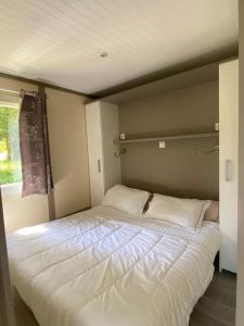 a large white bed in a room with a window at Les chalets des Îles in Borgo