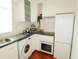 cocina blanca con lavadora y microondas en Cosy Home_A 30 minutes de Disneyland en Joinville-le-Pont
