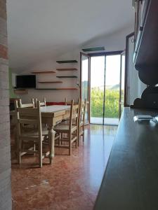 uma sala de jantar com uma mesa e cadeiras e uma televisão em A Casa di Emilie em Castelfiorentino