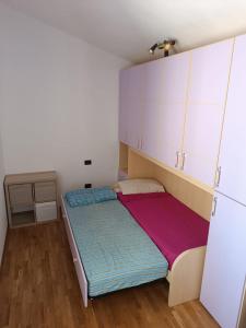 um pequeno quarto com uma cama e armários em A Casa di Emilie em Castelfiorentino