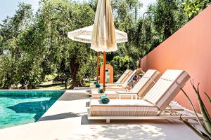 a group of chairs and an umbrella next to a swimming pool at Casa dei fiori in Corfu