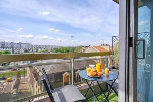 a table with a plate of food on a balcony at Rubis luxe proche Paris in Choisy-le-Roi