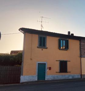 a house with a green door and two windows at Da Valentino e Manuela in Barberino di Mugello