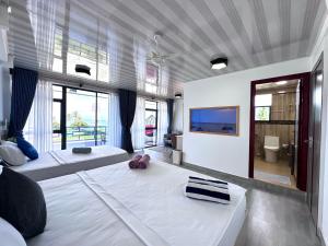 a large bedroom with two beds and a large window at Galaxy Sunrise Sea View in Fulidhoo