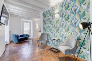 a living room with chairs and a geometric wall at BMGA l Magic Tiber 2Bdr Close to Piazza Navona in Rome