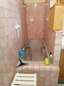 Baño alicatado de color rosa con bañera y lavabo en La maison de la vigne en Bauduen