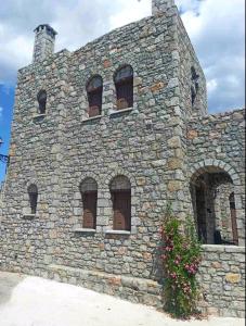キオスにあるAvgonima Family's Roomsの石造りの建物で、窓が数枚ある