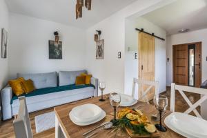 una sala de estar con una mesa y un sofá en Domek RogatY, en Szczawnica