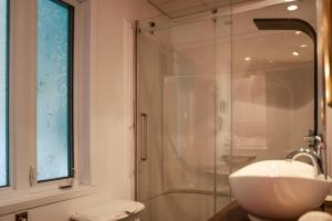La salle de bains est pourvue d'un lavabo et d'une douche en verre. dans l'établissement Maison sur la plage, à Chambord