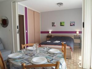 Zimmer mit einem Tisch mit Stühlen und einem Bett in der Unterkunft Appartement Balaruc-les-Bains, 2 pièces, 4 personnes - FR-1-503-122 in Balaruc-les-Bains
