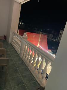 a white railing with a red flag on a balcony at night at Olympia in Ureki