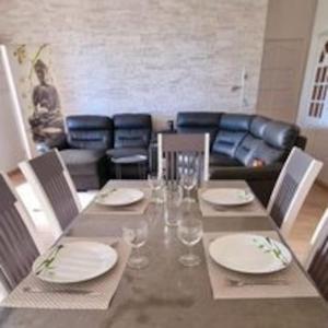 een eettafel met borden en wijnglazen bij La villa Les Terrasses sur le Port, 6 personnes in La Possession