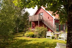 uma casa vermelha com uma mesa de piquenique em frente em Escape to PaulssonPaleo em Simlångsdalen