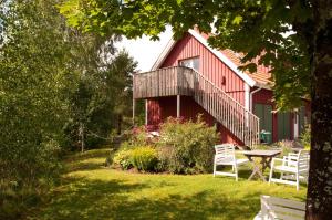a red house with a picnic table in front of it at Escape to PaulssonPaleo in Simlångsdalen