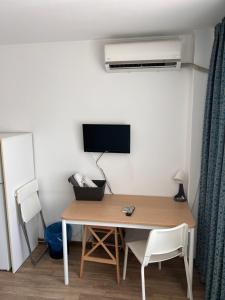ブカレストにあるVictoriei Residenceのテーブル、テレビ、デスク、椅子が備わる客室です。