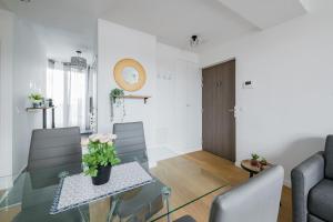 Cosy Appart Proche Paris في مونتروي: غرفة معيشة مع طاولة وكراسي زجاجية