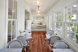 a dining room with tables and chairs and windows at Lavender, A Four Sisters Inn in Yountville