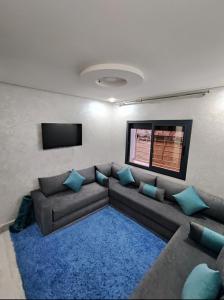 sala de estar con sofá y alfombra azul en Chalet villa QUE POUR LES FAMILLES en Imouzzer Kandar