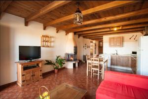 sala de estar con TV y cocina en Apartamentos Las Abuelas, en Helechosa