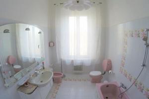 a pink bathroom with a sink and a toilet and a tub at GABRY'S Cozy 3-bedroom apartment near station & city center free parking in Livorno