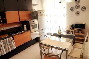 cocina con mesa y sillas y cocina con fogones en GABRY'S Cozy 3-bedroom apartment near station & city center, en Livorno