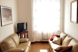 a living room with a couch and a television at GABRY'S Cozy 3-bedroom apartment near station & city center free parking in Livorno