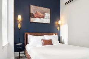 a bedroom with a white bed and blue walls at Sosuite at French Quarters - Rittenhouse Square in Philadelphia