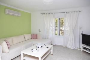 sala de estar con sofá blanco y TV en Comfortable Triplex 5 Min to the Beach with Garden in Bodrum, en Bodrum City
